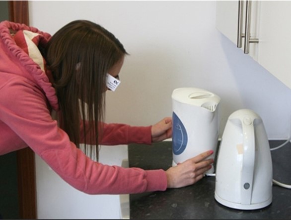 Photo of a researcher examining kettles while wearing simulation glasses
