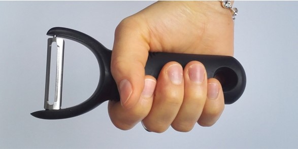 photo of the same potato peeler gripped by a hand, showing the large contact area between the hand and the peeler