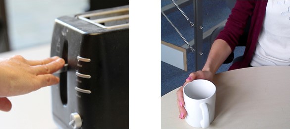 photo of a the control on a toaster being pushed down and a mug being pushed towards the body