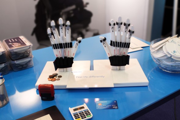A display stand at a workshop with simulation gloves and banking related materials.