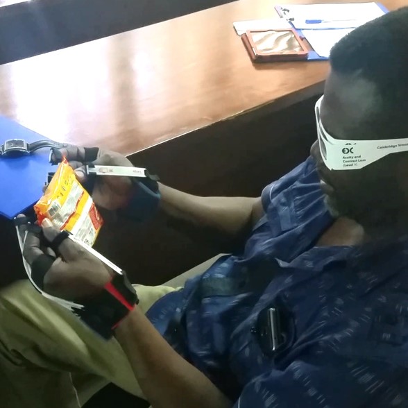 A participant examining food packaging while wearing simulation gloves and glasses