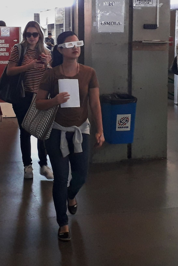 A woman wearing Cambridge Simulation Glasses, navigating in a public area.