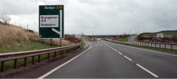 picture of driving on a motorway with a signpost and a slip road imminent