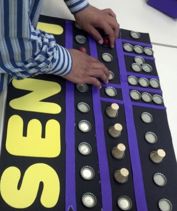 A large-scale game board with hands feeling the position of game pieces