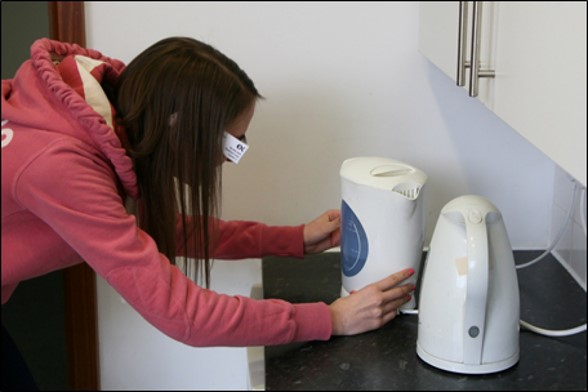 photograph showing a person wearing the glasses examining some kettles