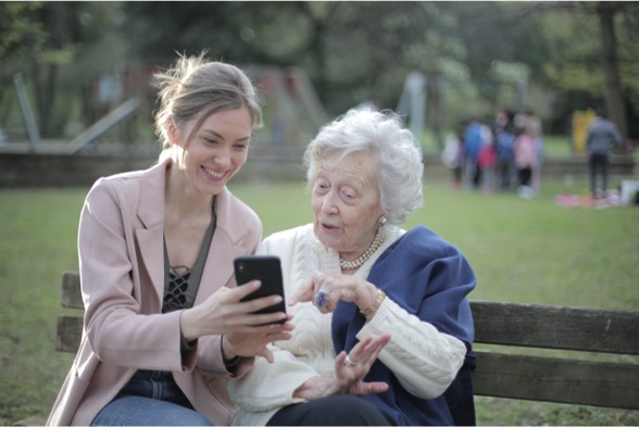 Photo of a younger and older woman looking at a smartphone together.