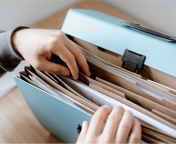 A person's hands opening a file folder